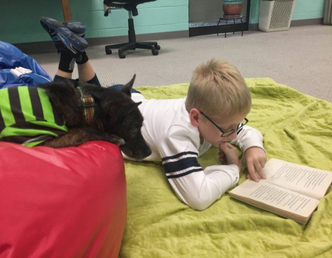 A young patron sharing a book with a dog at the Jonesborough Library